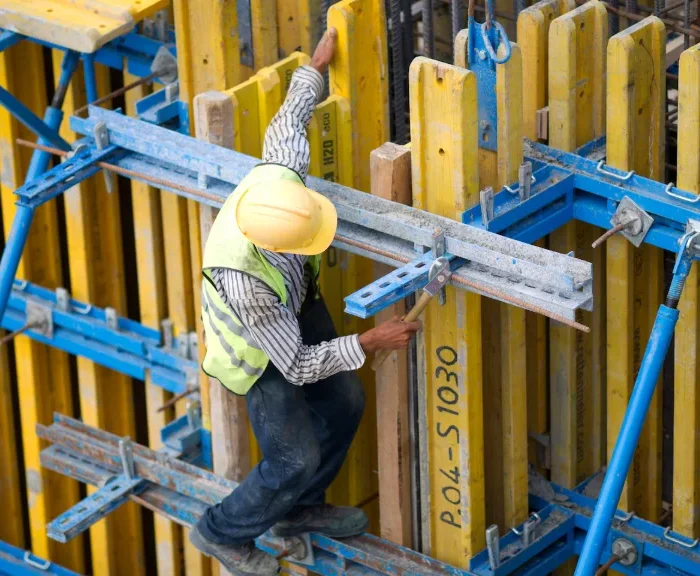 Construction worker installing formwork at height using San Jose Scaffolding Rental equipment.