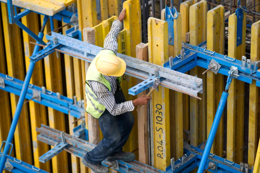 Construction worker installing formwork at height using San Jose Scaffolding Rental equipment.